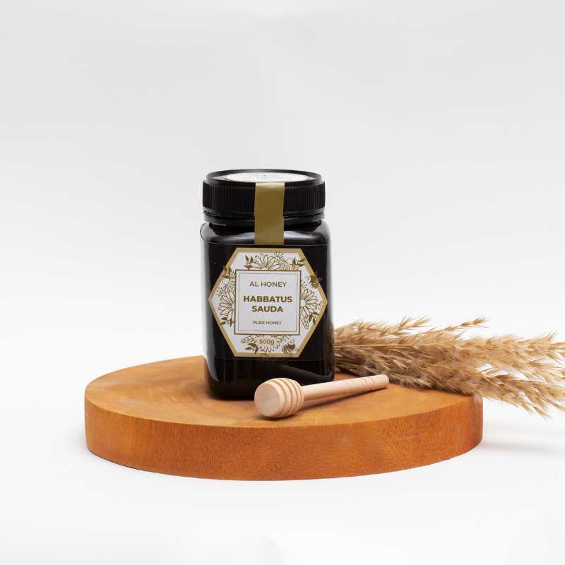 Front photo of Al Honey Blackseed Honey with wooden honey dipper
