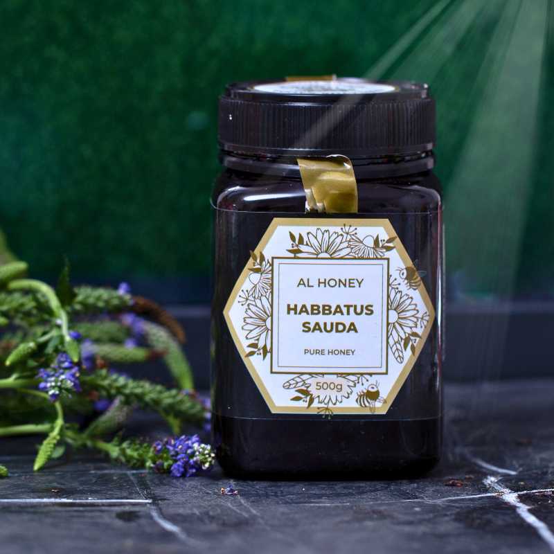 Front view of Al Honey Blackseed Honey and flowers on the side. Sign of nature and purity