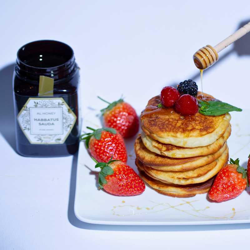 Al Honey Blackseed Honey drizzling on pancakes and fruits to replace artificial sweeteners