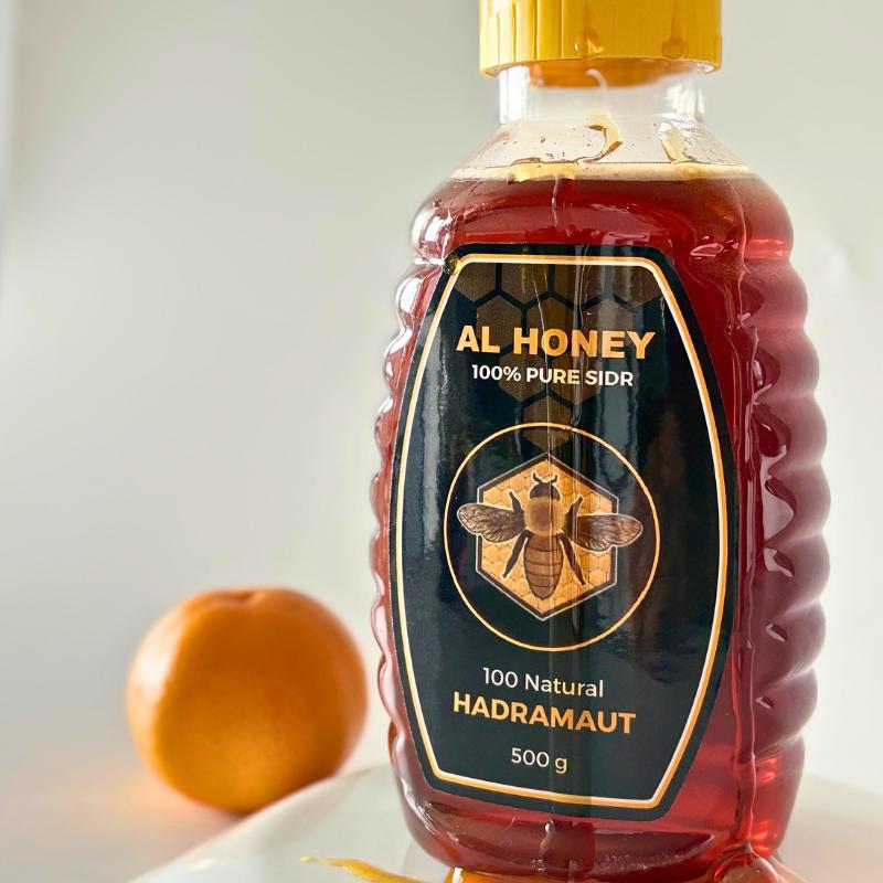 Front view of Al Honey premium sidr squeeze bottles with honey dripping