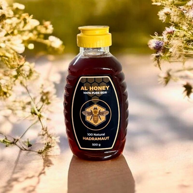 Front view of al honey premium sidr squeeze bottles and flowers