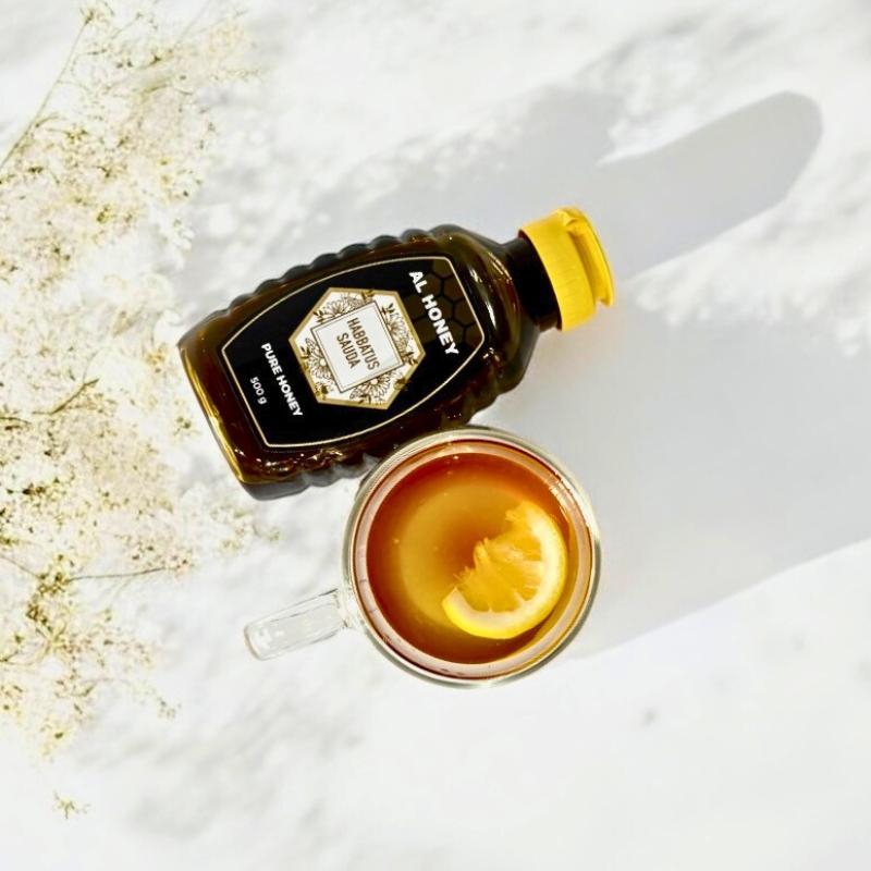 Top view of al honey blackseed squeeze bottle with lemon and blackseed drink