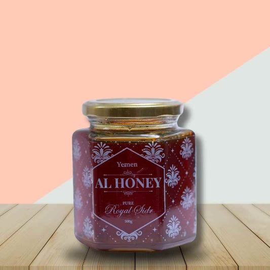 Al Honey Royal Sidr honey bottle on a table with pink and white background to showcase the bottle