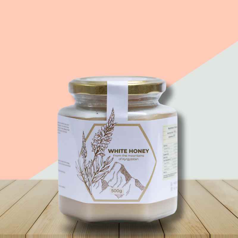 Al Honey white honey bottle on a table with pink and white background to showcase the bottle