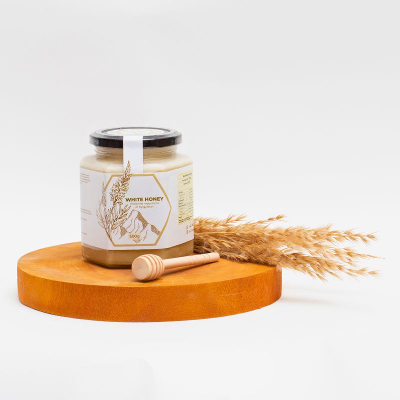 Al Honey's delicious creamy white fresh Honey. Showing Product and packaging along with a wooden stick.