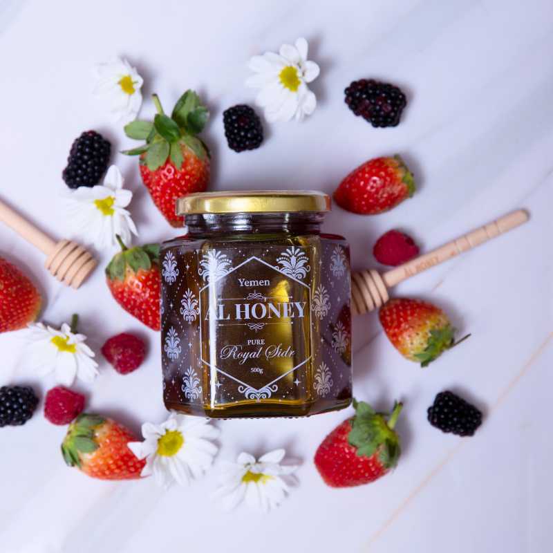 Front view of Al Honey Royal Honey from top with fruits and wooden dipper
