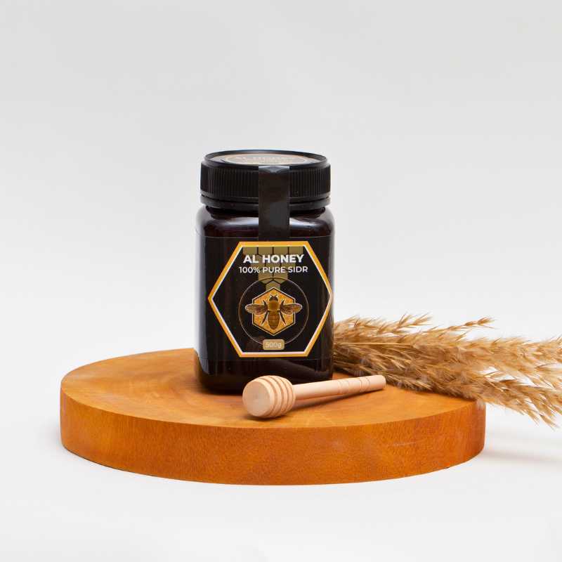 Front_photo_of_Al_Honey_Premium_sidr_with_wooden_dipper_and_flowers